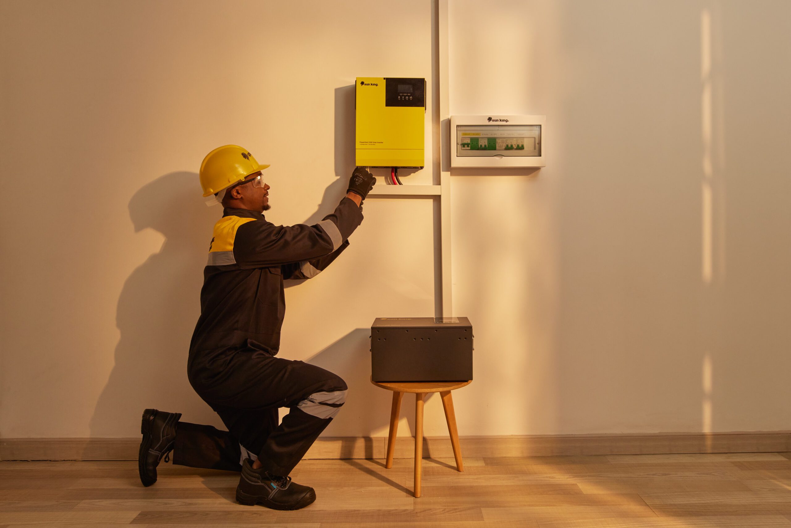 Sun King installer installs a rooftop solar inverter system inside a customer's house.